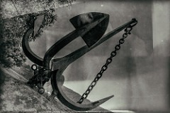 Vintage black and white photo of a large metal anchor on a textured surface, reminiscent of Kelley Seriano's whole brain approach. With a thick chain attached and set against a blurry background, it evokes an old, nostalgic atmosphere.